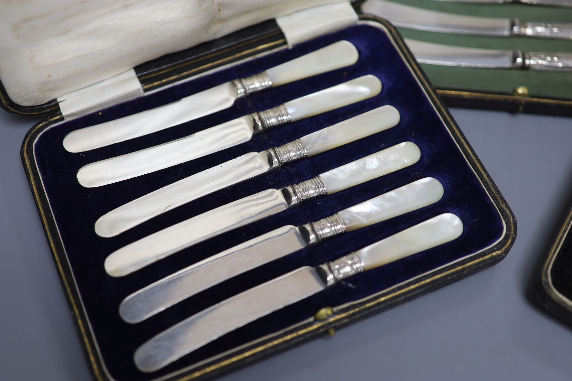A cased set of six silver pistol handles tea knives(a.f.) and two other cased sets of knives.